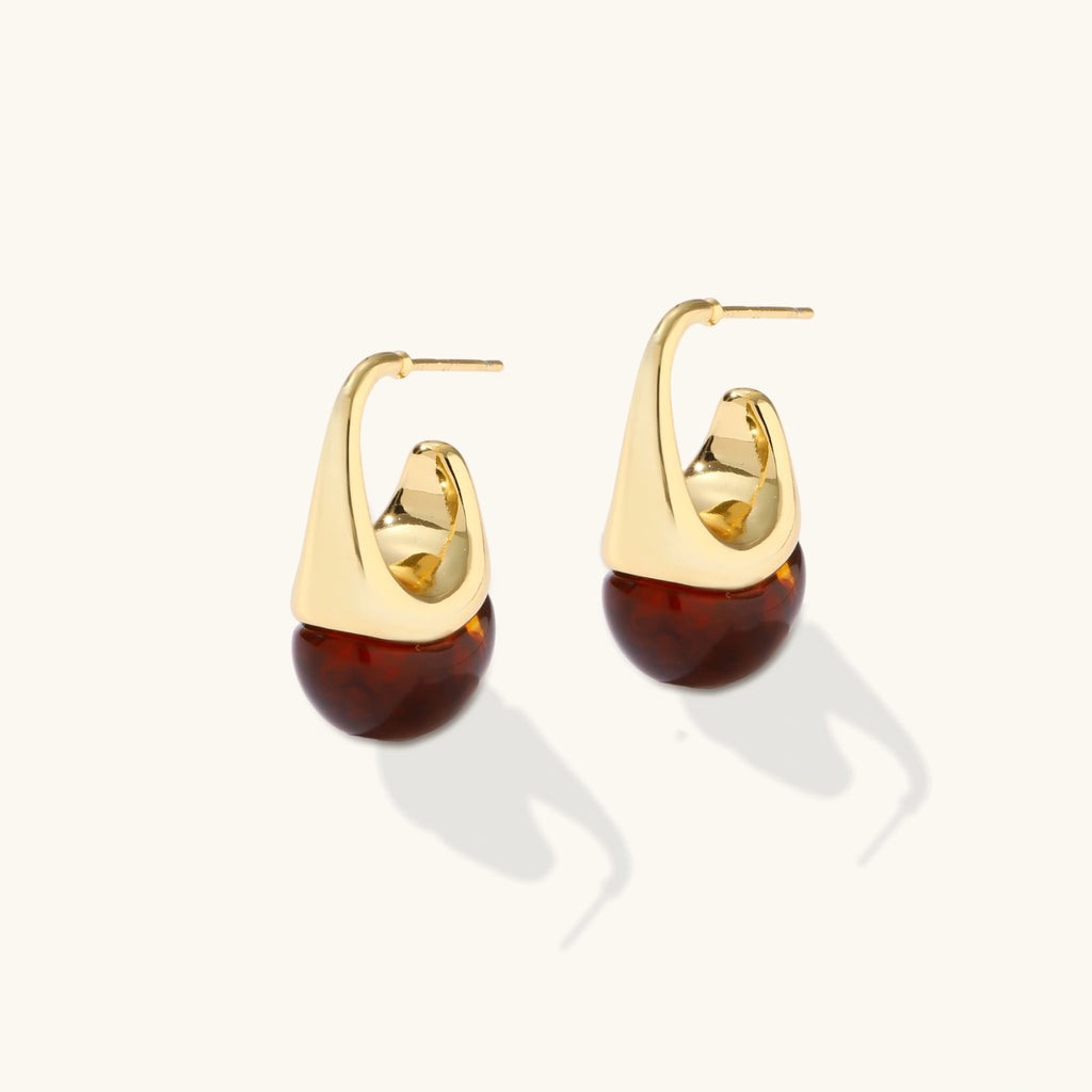 Modern drop earrings with curved gold-plated copper tops and amber resin bottoms creating an organic teardrop silhouette.