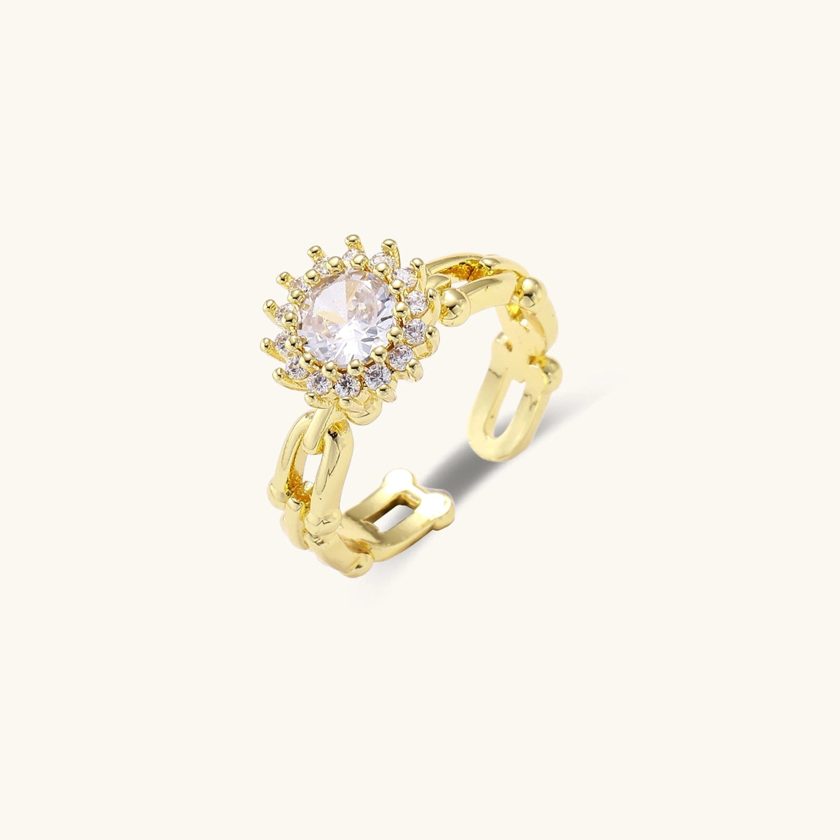 Two adjustable gold rings: chain-link band and halo-style ring with cubic zirconia stones on cream background