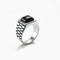 Silver stainless steel signet ring with checkered band texture, beaded border, and square black onyx cabochon stone center.